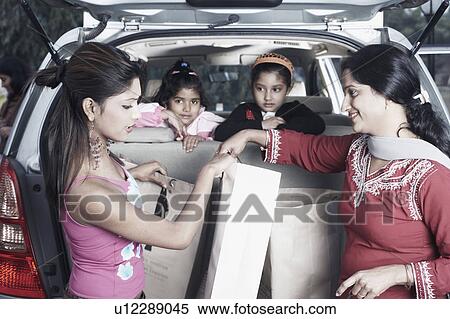 Portrait of two girls leaning against a car seat with their sister and their mother in the back View Large Photo Image Stock Photography - Portrait of two girls leaning against a car seat with their sister and their mother in the back. Fotosearch