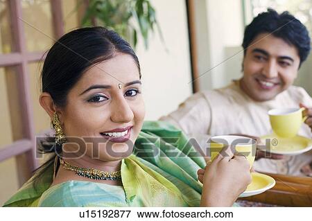 Young couple holding cups of tea View Large Photo Image Stock Photo - Young couple holding cups of tea. Fotosearch