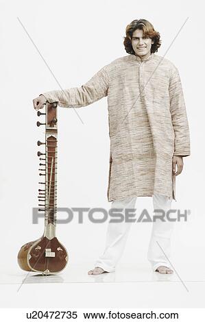 Stock Photography - Portrait of a male musician holding a sitar. Fotosearch