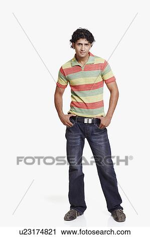 Portrait of a young man standing with his hands in his pockets View Large Photo Image Stock Image - Portrait of a young man standing with his hands in his pockets. Fotosearch