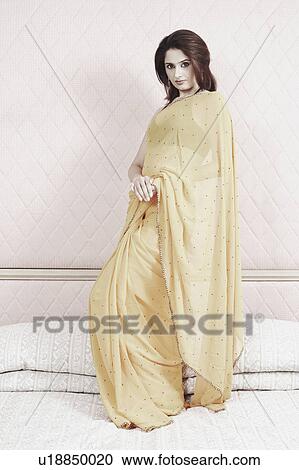 Portrait of a young woman standing on the bed View Large Photo Image Stock Image - Portrait of a young woman standing on the bed. Fotosearch