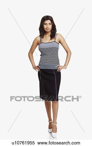 Stock Photography - Portrait of a young woman standing with arms akimbo. Fotosearch