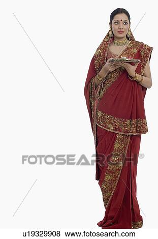 Young woman holding a plate of traditional offerings View Large Photo Image Stock Photo - Young woman holding a plate of traditional offerings. Fotosearch