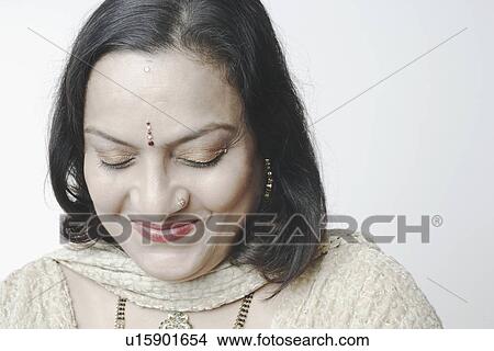 Picture - Close-up of a mature woman with her eyes closed smiling. Fotosearch