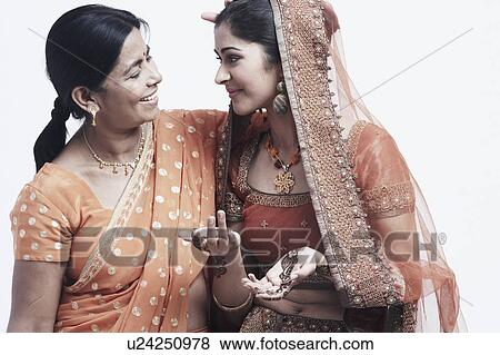 Close-up of a mother standing with her daughter View Large Photo Image Stock Photo - Close-up of a mother standing with her daughter. Fotosearch