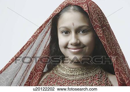 Stock Image - Portrait of a teenage girl smiling with a stole on her head. Fotosearch