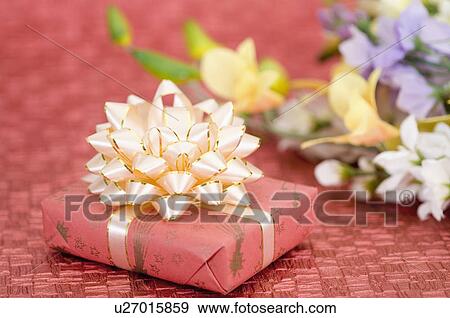 Close-up of a gift and flowers View Large Photo Image Stock Photo - Close-up of a gift and flowers. Fotosearch