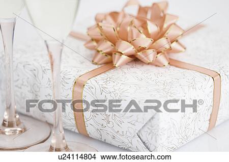 Close-up of a gift with two champagne flutes View Large Photo Image Picture - Close-up of a gift with two champagne flutes. Fotosearch