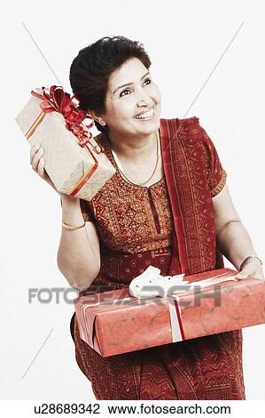 Close-up of a mature woman holding gifts View Large Photo Image Stock Image - Close-up of a mature woman holding gifts. Fotosearch