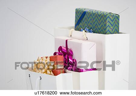 Stock Image - Close-up of gifts in three paper bags. Fotosearch