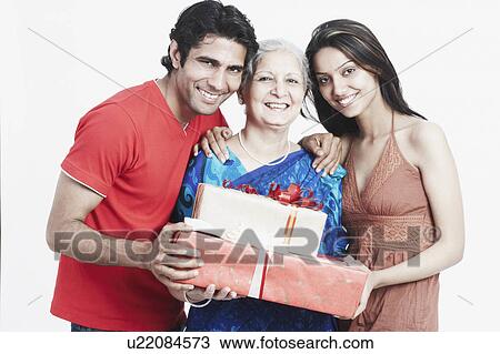 Portrait of a mature woman holding gifts with her two grandchildren View Large Photo Image Stock Image - Portrait of a mature woman holding gifts with her two grandchildren. Fotosearch