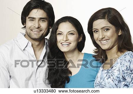 Stock Image - Close-up of two young women and a young man laughing. Fotosearch
