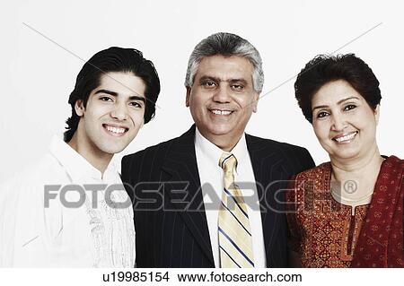 Picture - Portrait of a mature couple standing with their son and smiling. Fotosearch