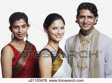 Stock Photograph - Portrait of a young man standing and smiling with two young women. Fotosearch