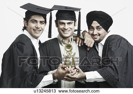 Portrait of three male graduates holding a trophy View Large Photo Image Stock Image - Portrait of three male graduates holding a trophy. Fotosearch