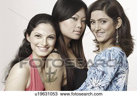 Stock Image - Portrait of three young women smiling. Fotosearch