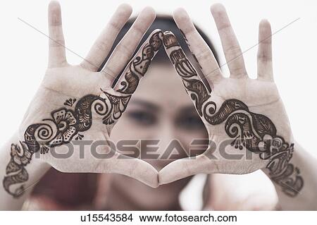 Picture - Close-up of a young woman with henna tattoo's on her hands. Fotosearch