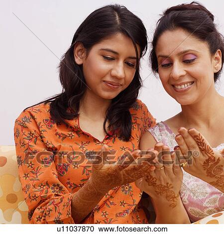 Close-up of two young women looking at their henna tattooed hands View Large Photo Image Stock Image - Close-up of two young women looking at their henna tattooed hands. Fotosearch