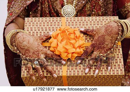 Mid section view of a bride holding a gift View Large Photo Image Stock Photo - Mid section view of a bride holding a gift. Fotosearch