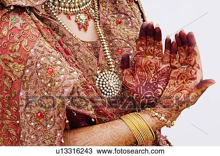 Stock Image - Mid section view of a bride showing her henna tattooed hands. Fotosearch