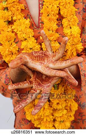 Stock Image - Mid section view of a woman showing her henna tattooed hands. Fotosearch