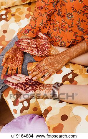 Mid section view of two women showing their henna tattooed hands View Large Photo Image Picture - Mid section view of two women showing their henna tattooed hands. Fotosearch
