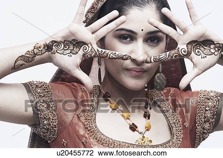 Stock Image - Portrait of a young woman with henna tattoo's on her hands. Fotosearch