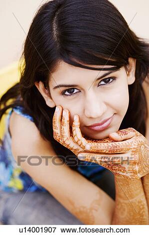 Stock Photo - Portrait of a young woman with her hand on her chin. Fotosearch