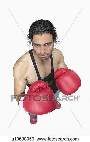 Stock Image - High angle view of a young man wearing boxing gloves. Fotosearch