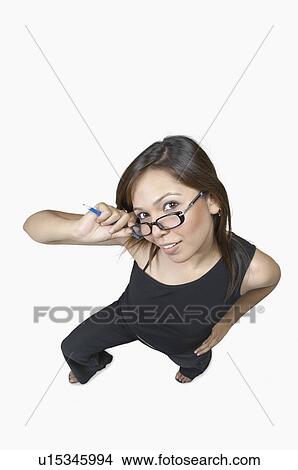 High angle view of a young woman adjusting her eyeglasses and smiling View Large Photo Image Picture - High angle view of a young woman adjusting her eyeglasses and smiling. Fotosearch