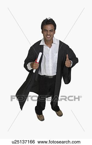 Stock Photograph - Portrait of a college student holding his diploma and showing thumbs up sign. Fotosearch