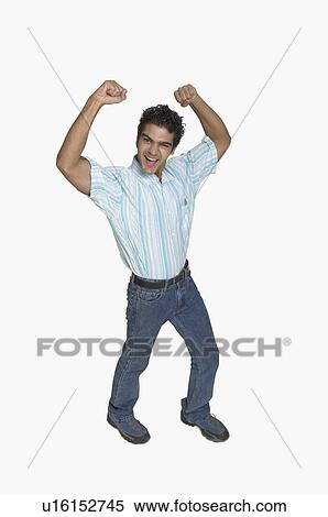 Stock Photography - Portrait of a young man clenching his fists and laughing. Fotosearch