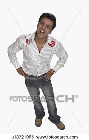 Stock Photography - Portrait of a young man standing with arms akimbo. Fotosearch