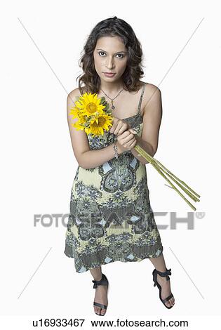 Stock Photo - Portrait of a young woman holding a bunch of Sunflowers. Fotosearch