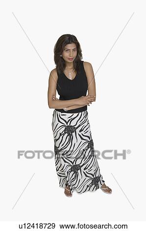 Stock Photo - Portrait of a young woman standing with her arms crossed. Fotosearch