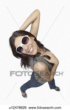 Stock Photograph - Portrait of a young woman wearing sunglasses and smiling. Fotosearch