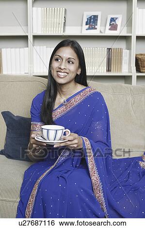 Stock Photograph - Close-up of a young woman holding a cup of tea. Fotosearch