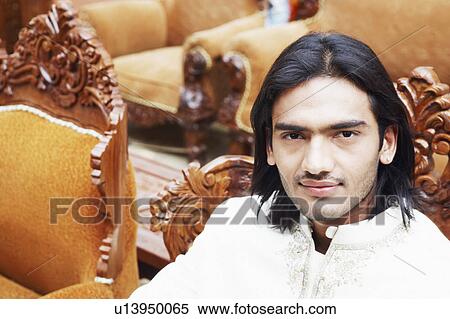 Portrait of a young man sitting in an armchair View Large Photo Image Stock Photography - Portrait of a young man sitting in an armchair. Fotosearch