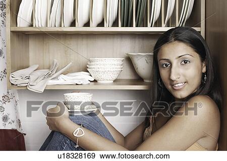 Portrait of a young woman holding a cup of coffee View Large Photo Image Stock Photo - Portrait of a young woman holding a cup of coffee. Fotosearch