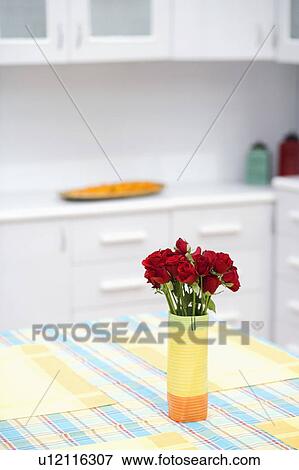 Stock Photo - Roses in a vase on the dining table. Fotosearch