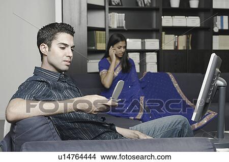 Picture - Side profile of a young man operating a mobile phone. Fotosearch