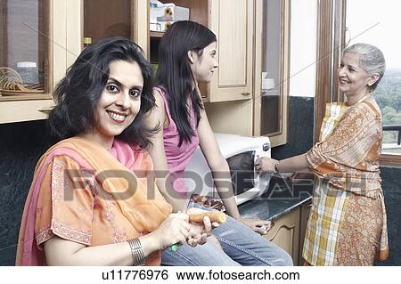 Three women talking in the kitchen View Large Photo Image Stock Photograph - Three women talking in the kitchen. Fotosearch