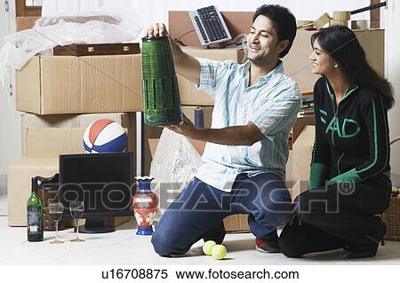 Young couple looking at a vase View Large Photo Image Stock Photography - Young couple looking at a vase. Fotosearch