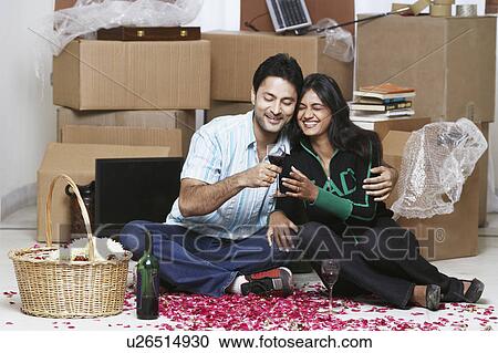 Young couple sitting on the floor View Large Photo Image Stock Image - Young couple sitting on the floor. Fotosearch