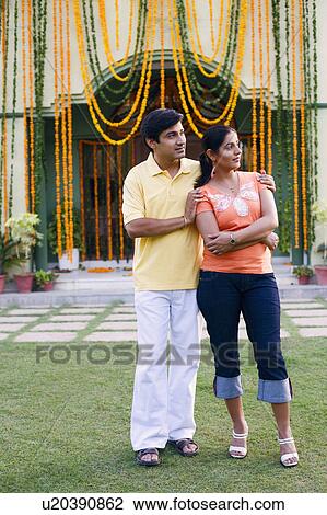 Young couple standing in front of a decorated house View Large Photo Image Stock Image - Young couple standing in front of a decorated house. Fotosearch