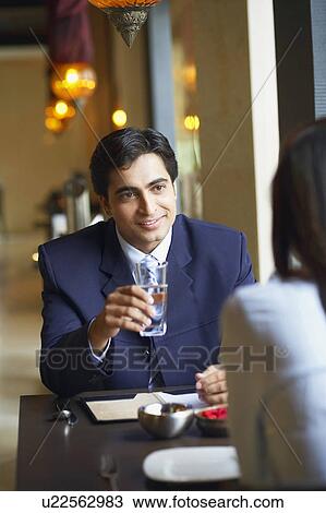 Stock Image - Businessman and a businesswoman sitting in a restaurant. Fotosearch