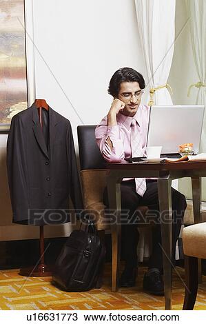 Stock Image - Businessman sitting in an office and using a laptop. Fotosearch