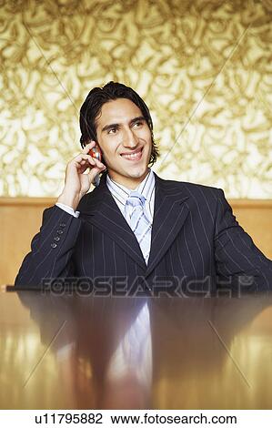 Stock Image - Close-up of a businessman talking on a mobile phone and smiling. Fotosearch