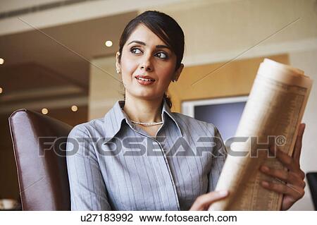 Stock Image - Close-up of a businesswoman holding a newspaper. Fotosearch