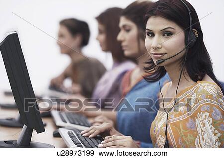 Close-up of four businesswomen sitting in front of computers View Large Photo Image Stock Photo - Close-up of four businesswomen sitting in front of computers. Fotosearch